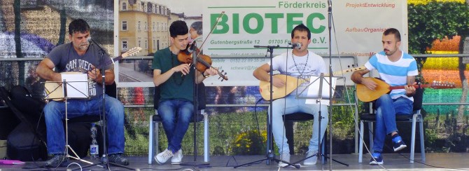Vier Männer spielen verschiedene Saitenintrumente auf dem Sommerfest des Förderkreis Biotec e.V. in Freital.