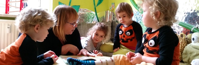 Tagesmutter Sylvia Zabel-Thäder, eine blonde, freundlich blickende Frau, sitzt zwischen den fünf Kindern, die sie in ihrer Kindertagespflegestelle in Leipzig betreut und bildet.