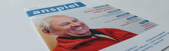 Ein Heft der ersten Ausgabe des Verbandsmagazins anspiel. des Paritätischen Sachsen liegt auf einer weißen Fläche. Auf dem Cover ist ein lachender älterer Herr zu sehen.