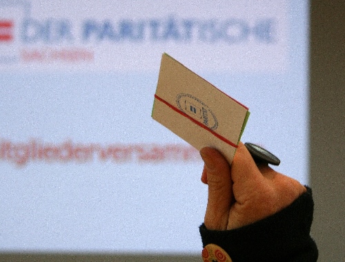 Symbolbild: Eine Hand hält eine Stimmkarte in die Höhe.