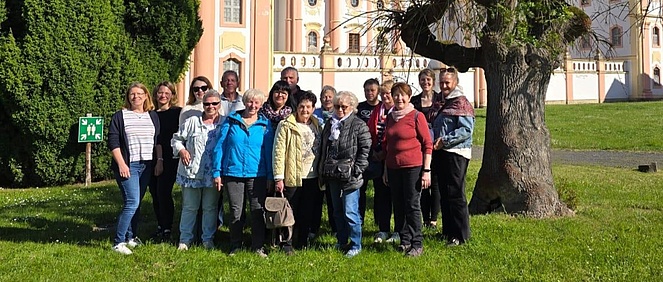 Ehrenamtsfahrt 2025: Ehrenamtliche stehen gut gelaunt in einem Park.