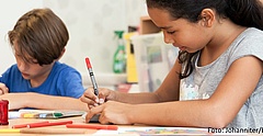 Zwei Kinder sitzen an einem Tisch und malen. (Foto: Johanniter/Birte Zellentin)