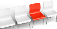 Vier Stühle stehen nebeneinander. Der dritte ist rot, die anderen sind weiß.