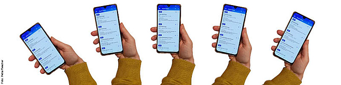 Eine Hand hält ein Smartphone auf der eine Kita-App angezeigt wird. (Foto: Petra Fleischer)