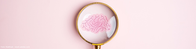 Symbolbild: Ein gezeichnetes Gehirn unter einer Lupe