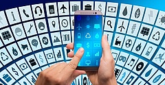 Symbolbild: Hände tippen auf einem Smartphone und sind umringt von Symbolen digitaler Anwendungen. (gerald - pixabay.com)