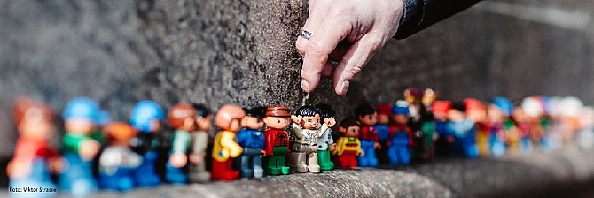 Symbolbild: Eine Hand greift nach einer Spielfiguren in einer Reihe vieler Figuren. (Foto: Viktor Strasse)