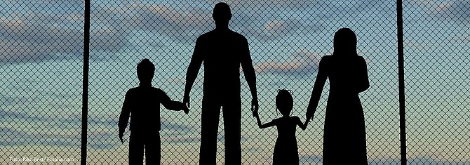 Silouetten einer Familie hinter einem Zaun (Zuwanderung, Migration, Flucht), Foto: Riko Best/ Fotolia.com