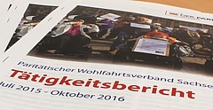 Mehrere Exemplare des Tätigkeitsberichts 2015/2016 des Paritätischen Sachsen liegen schräg übereinander. Auf dem Titelblatt ist das Verbandslogo sowie ein Bild des Protestes gegen das Bundesteilhabengesetzes im September 2016 in Dresden zu sehen.