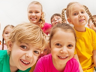 Symbolbild: Eine Gruppe von Kindergartenkindern lacht in die Kamera.