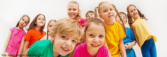 Symbolbild: Eine Gruppe von Kindergartenkindern lacht in die Kamera.