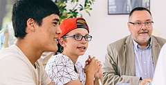 Drei Jugendliche und ein Mann sitzen an einem Tisch und Diksutieren. Das Bild illustriert einen Artikel über Mitbestimmung im SOS-Kinderdorf Zwickau des Magazins anspiel. (Foto: Michael Bader, Archiv SOS-KInderdorf e.V.)