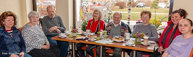 Menschen sitzen in einem Cafe an einem Tisch mit Kuchen und Kaffee. (Foto: Klaus Poepperl)