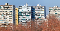 Symbolbild: Verschiedenfarbige Wohnblöcke vor einem blauen Himmel. 