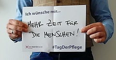 Aktion "Tag der Pflege" 2018, Jemand hält ein Schild mit der Aufschrift: "Ich wünsche mir mehr Zeit für die Menschen!", #TagDerPflege